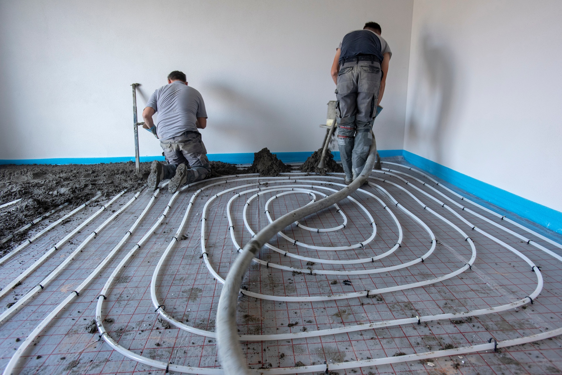 Handwerker verlegen Rohre der Fußbodenheizung | Bodenmarkierung